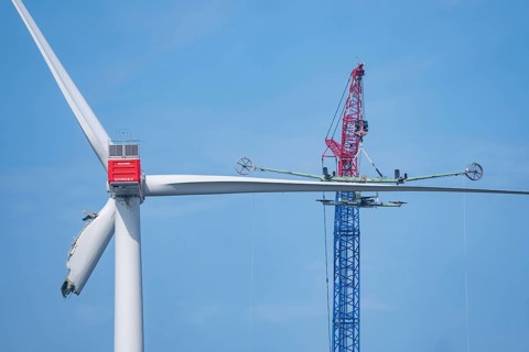Dismantling a defective wind turbine, dismantling the two intact wings with a large crane, bent