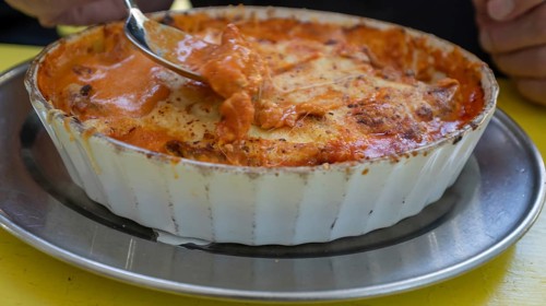 Lasagna in a round, white casserole dish served in a garden restaurant, Franconia, Bavaria, Germany
