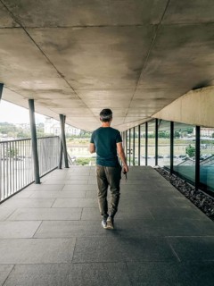 The view from behind walking a man in casual clothes, A man in casual attire walks down a modern,