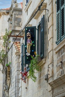 A large puppet adorns the decorated window of an arts and crafts shop, Old Town, Dubrovnick,