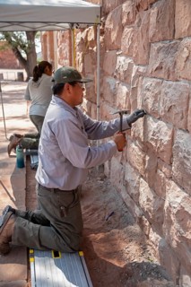 Ganado, Arizona - National Park Service workers repair the wall of the visitor center at the