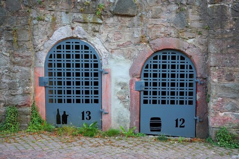 Two doors with bars to the wine cellar, cellar doors with metal mesh and house numbers, wine
