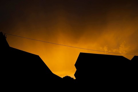 Silhouette, thunderstorm over residential area, residential buildings, power line, bright yellow