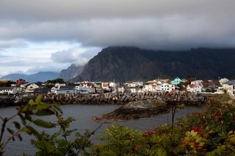 View of the picturesque fishing village against a gigantic mountain backdrop with deep clouds and