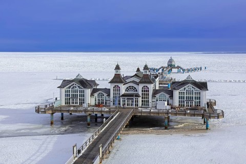 Seebrücke Sellin, restaurant on jetty, pier along frozen Baltic Sea on the island Rügen in the snow