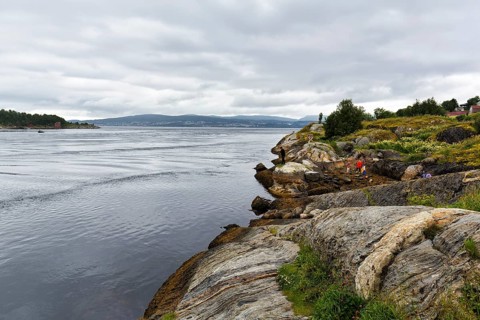 Hikers on the Saltstraumen tidal stream, cloud cover, near Bodo, Northern Norway, Norway