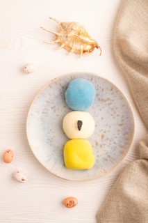 Japanese Mochi Cakes on white wooden background and linen textile, top view, flat lay, close up