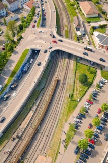 Aerial view of a road junction with passing cars next to railroad tracks, Leonhard Weiss