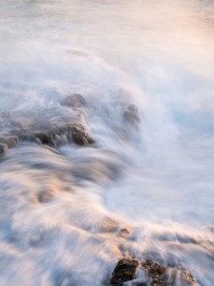 Seawater flows over lava rocks. Long exposure, morning light. Coast near Puerto de Talavera, La