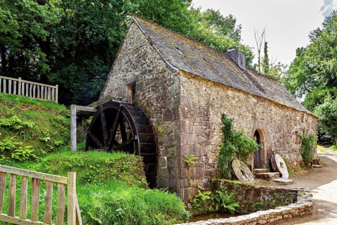 An old mill in the countryside with a large water wheel and moss-covered stones, The mill of the