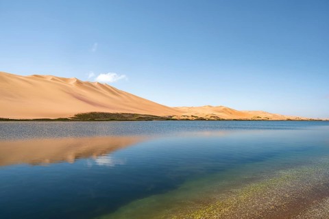 Sand dunes are reflected in Sandwich Harbour Lagoon, Impressive Desert Landscape, Namib Naukluft