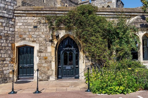 Dark painted doors set within a stone archway mark the entrance to the Winchester Tower, part of