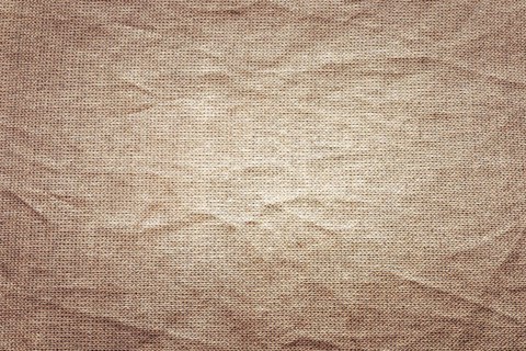 Textured brown fabric with visible creases and folds. The surface appears soft and natural,