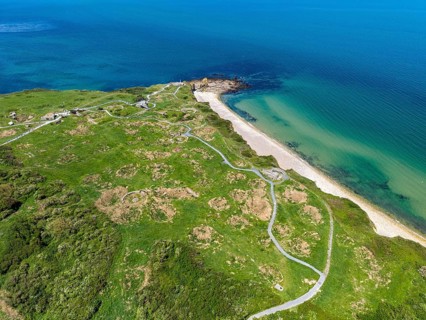 Aerial view of the historic Pointe du Hoc headland on the cliffs of Normandy. The green cliff rises