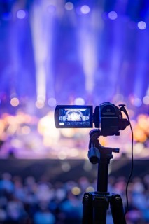 Camera on stand focuses on an illuminated concert stage, Calwer Klostersommer Festival, Hirsau