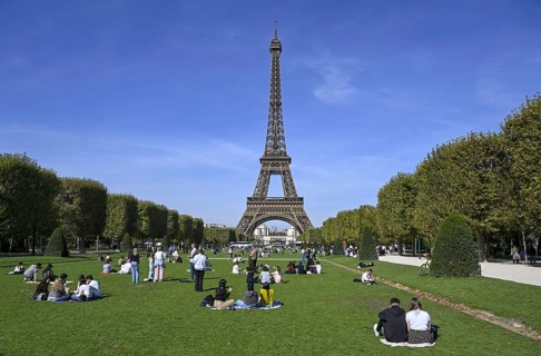 People in a meadow in front of the Eiffel Tower, Champ de Mars, Paris, Île-de-France region, France