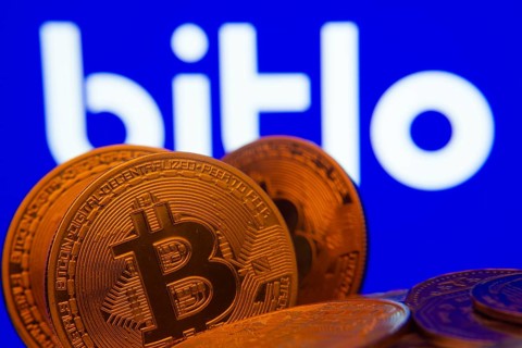 Dhaka, Bangladesh- 03 Sep 2025: Close-up of Bitcoin coins with the Bitlo logo visible on a screen