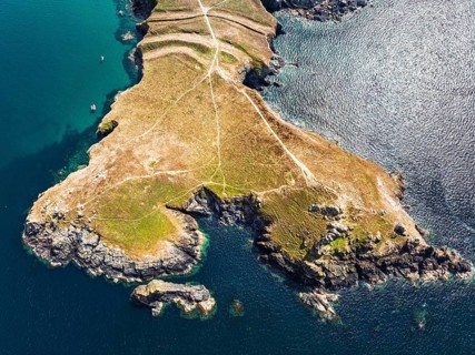 Seven Souls Rock and Pentire Point and Bay over Padstow Bay from a drone, Polzeath, Cornwall,