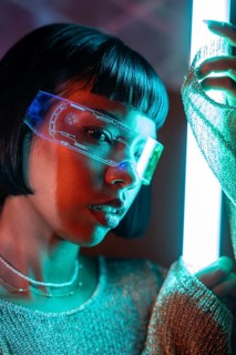 A Latin woman explores a virtual reality experience while wearing sleek, futuristic VR glasses. The