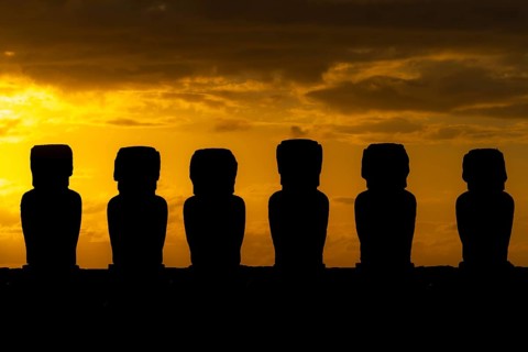 Moai statues as silhouettes in front of an orange sunrise sky, Ahu Tongariki, Easter Island, Chile
