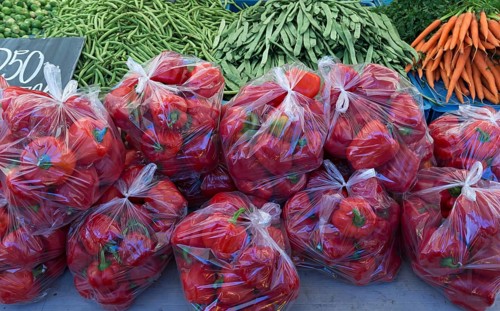 Red peppers (Capsicum) packed in plastic bags on a fruit stall, Enschede, Netherlands