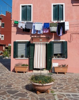 Pink house facade with clothesline, windows and front door, colourful houses, alleys on the island