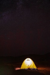 Starry sky at night, in front of it an illuminated tent, night shot, Rub al Khali desert, Dhofar