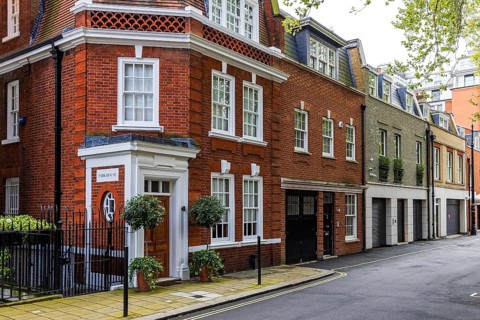 Red brick and white-painted former coach houses line Wood's Mews near Park Lane, Mayfair, London,