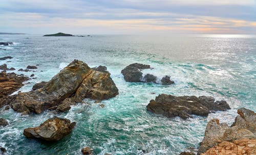 Land and seascape At the rocky and sandy coastline of the atlantic ocean in Porto Covo, Portugal