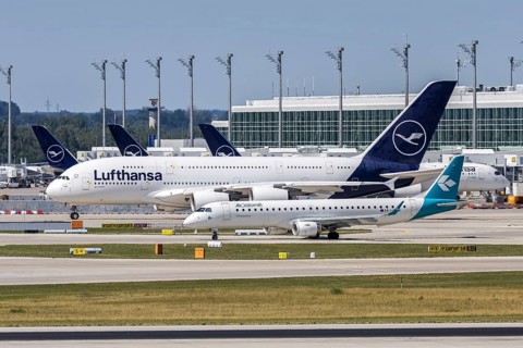 An Embraer 195 and Airbus A380-800 Air Dolomiti and Lufthansa aircraft at Munich Airport, Germany