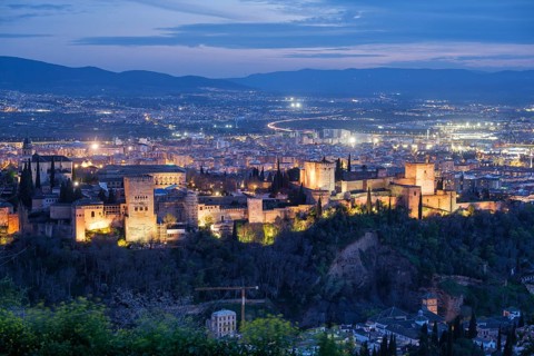 Elevated night view of the illuminated Alhambra fortress and palace complex in Granada, Spain, with
