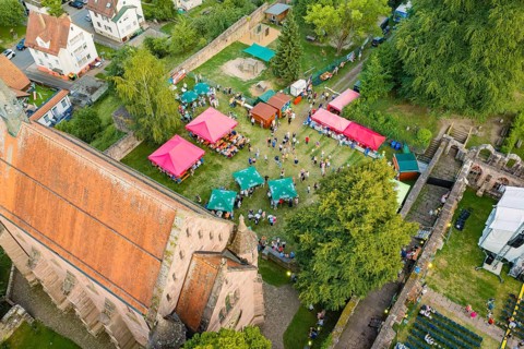 Bird's-eye view of summer party with colorful tents, crowds and green surroundings, Calwer