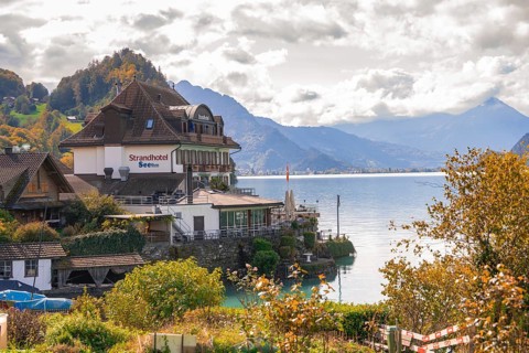 Inviting hotel on the lakeshore with magnificent mountain panorama, Lake Brienz, Switzerland