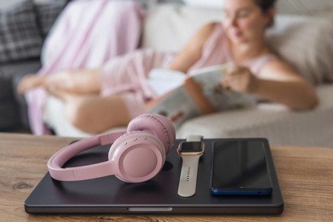 Engaging in a digital detox by relaxing on the couch, reading a book, while enjoying a peaceful