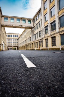 Deserted, long road between old industrial buildings, Motorworld, Rüsselsheim, Germany