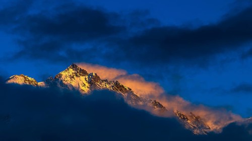 Snow-covered summit of the Weisshorn mountain, illuminated by the evening sun, view from Grimentz,