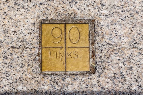 A brass plaque marked 90 links forms part of the Imperial Standards of Length set into the wall and