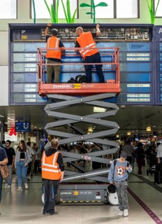 Technicians working on an electronic information board, display board for train connections at
