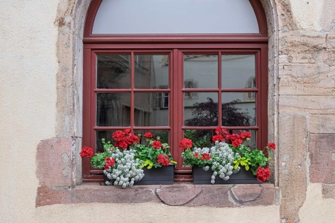 Arched window with floral decoration, old town of Colmar, Alsace, France
