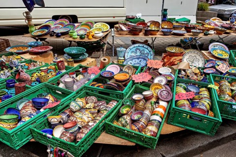 Colourful, handmade ceramic bowls and jugs on display at a market stand, market stalls in Brittany