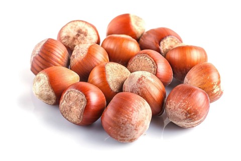 Pile of hazelnuts with shell isolated on white background. close up
