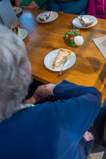 Several people sit at a table in a café, pieces of cake spread on plates, Cafe Kuh, Deckenpfronn,