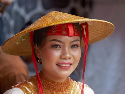 Toraja woman in traditional colourful clothes with rice straw hat, smiling, portrait, Tana Toraja,