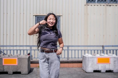 Asian happy girl dancing urban free style in the city in an industrial space outdoors