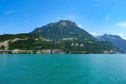 Lake Lucerne in front of an imposing mountain range under a bright blue sky, Seelisberg, Canton of