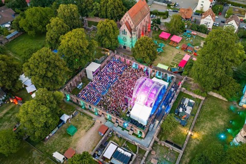 Open air concert with large crowds and colorful lights at night, Calwer Klostersommer Festival,