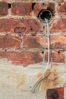 Detroit, Michigan - Unconnected electrical wires emerging from a pipe outside an old industrial
