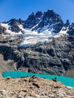 Hikers at the lagoon below mountain Cerro Castillo, view towards glacier and peak Cerro Castillo,