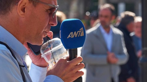 Man with microphone of a news channel conducting an interview in public, visit of the Federal