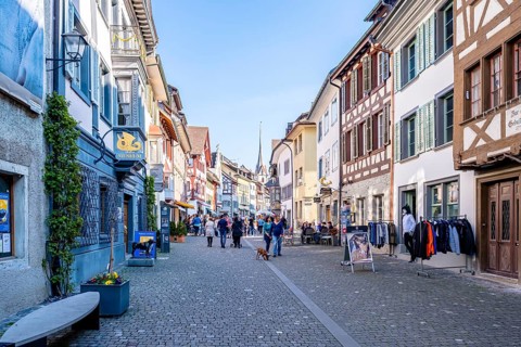 Busy old town street with half-timbered houses, cafés and shops on a sunny day, Stein am Rhein,